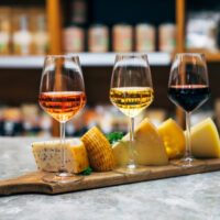 Wine bottles, glasses and cheese in restaurant